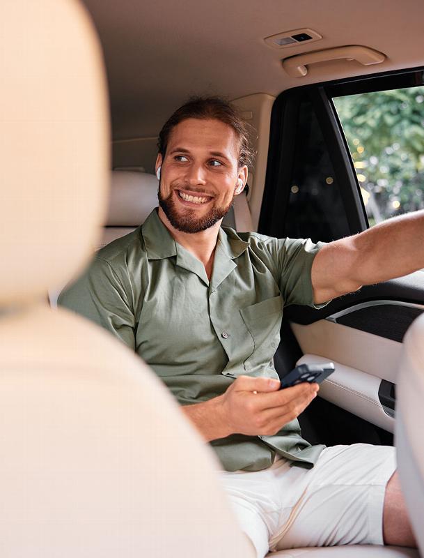 man smiling in the back of car