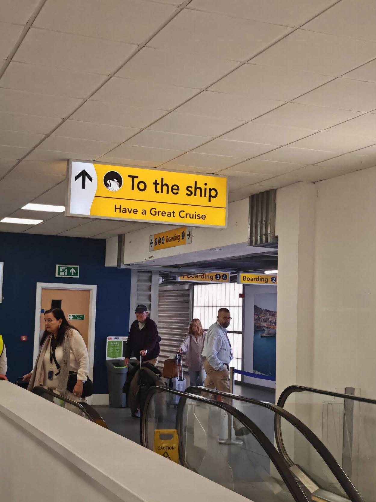 passengers following To the Ship sign at Southampton Cruise Terminal